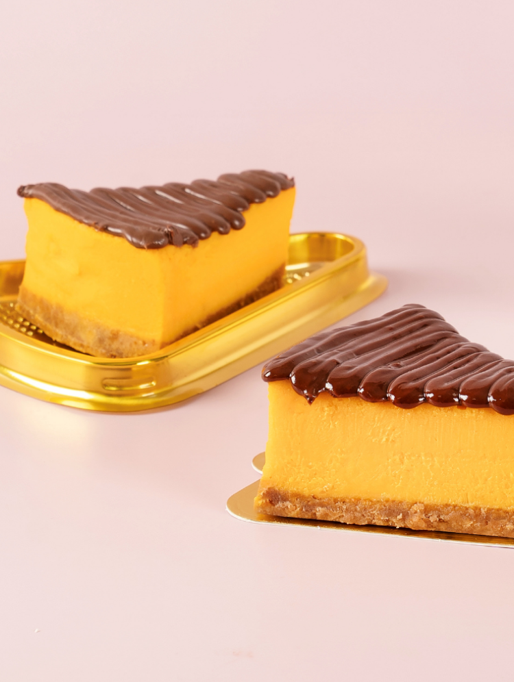 Chocolate Topped Cheesecake Slice by Pam Bakery, featuring rich creamy cheesecake with a buttery biscuit base and smooth chocolate glaze. Freshly baked premium cheesecake dessert available for online cake delivery, birthday celebrations, party orders, and gourmet dessert lovers in Rohtak, Haryana. Perfect handcrafted cheesecake from Pam Bakery for special occasions and sweet cravings.