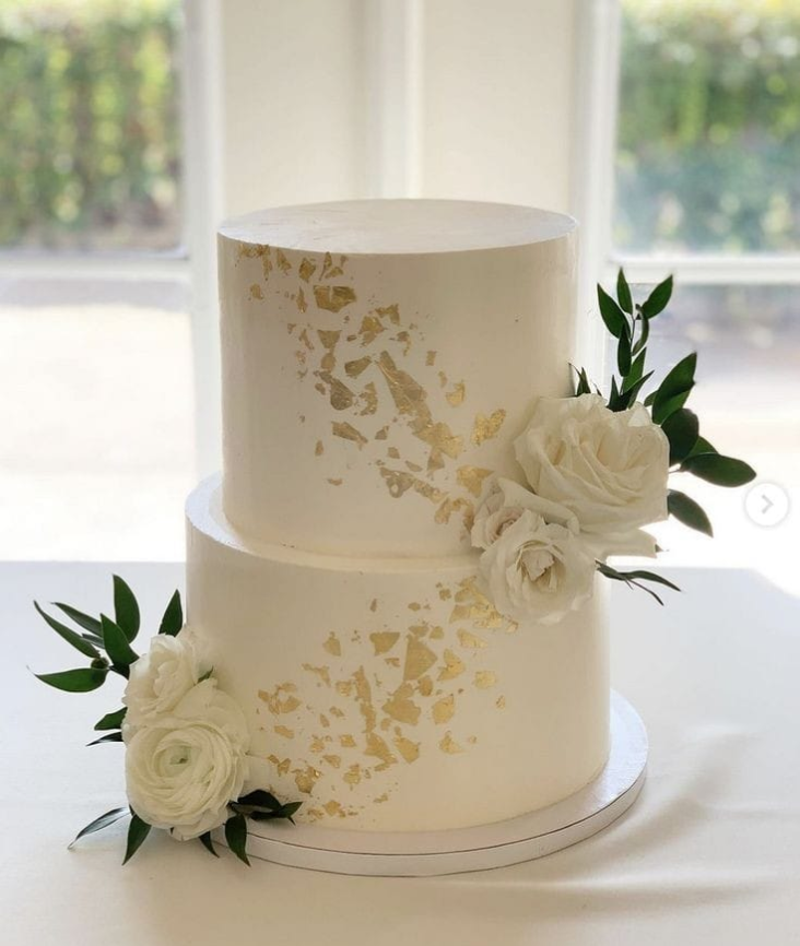 Eggless 2 tier white wedding cake with gold leaf and fresh white roses by Pam's Bakery Noida